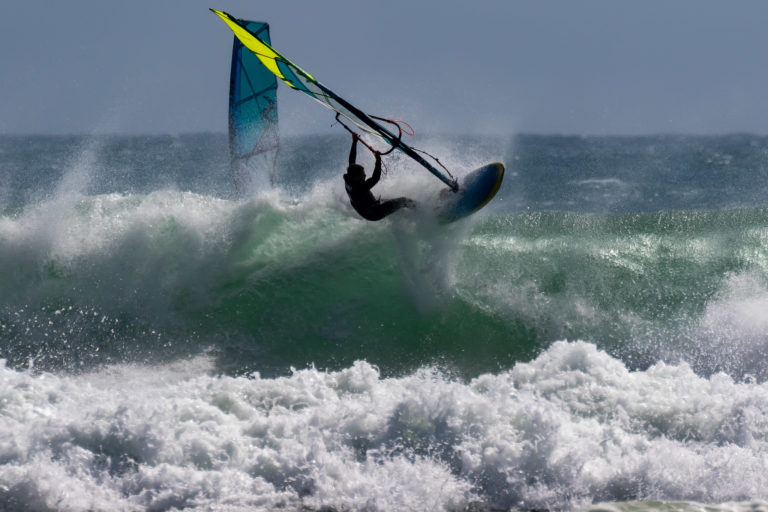 Windsurfer on a wave in Taranaki doing a top turn, New Zealand