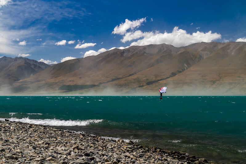 Wingfoiler on Lake Ohau, with dust blowing up in the background