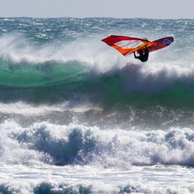 Windsurfer on a wave in Taranaki, New Zealand