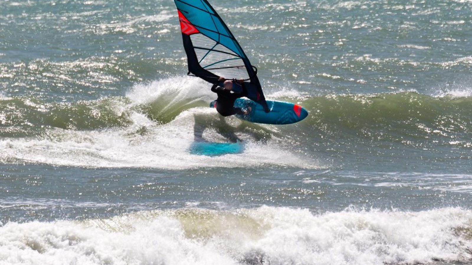 Windsurfer on a wave in Taranaki doing a top turn, New Zealand